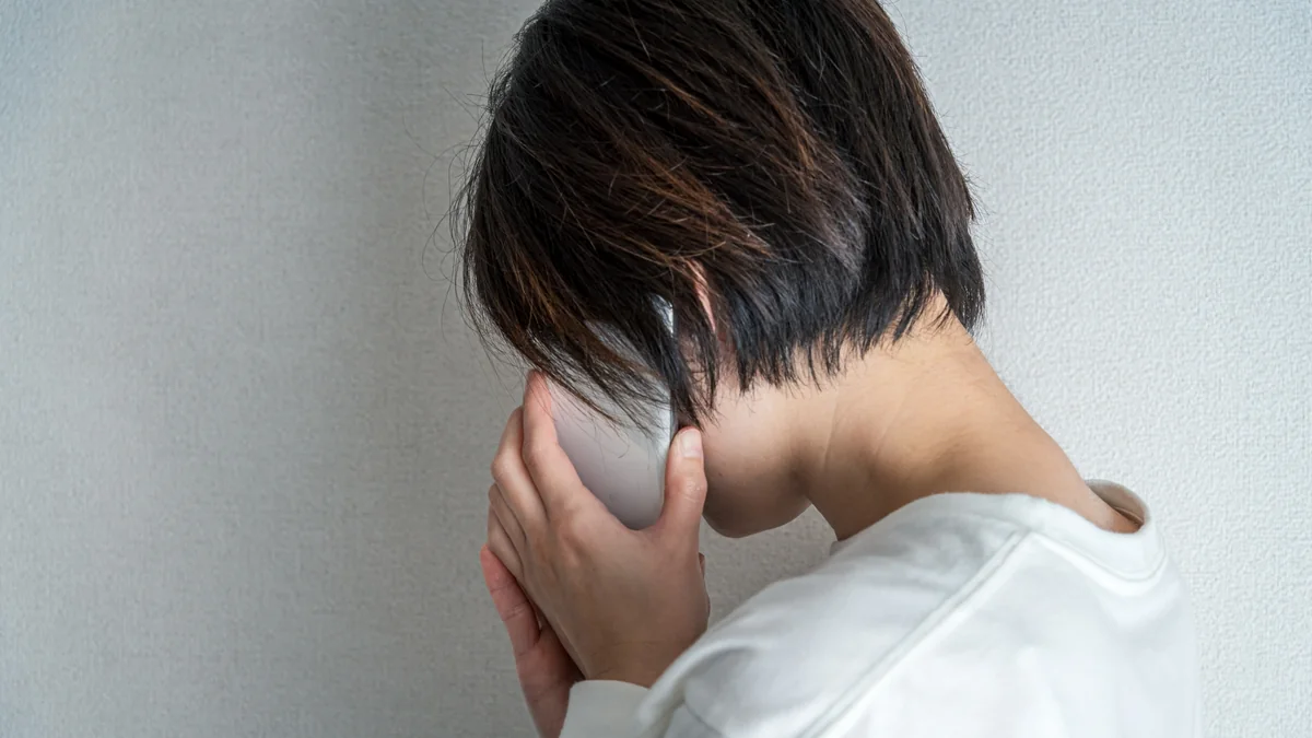 ストーカー被害に追い詰められ、うずくまる人